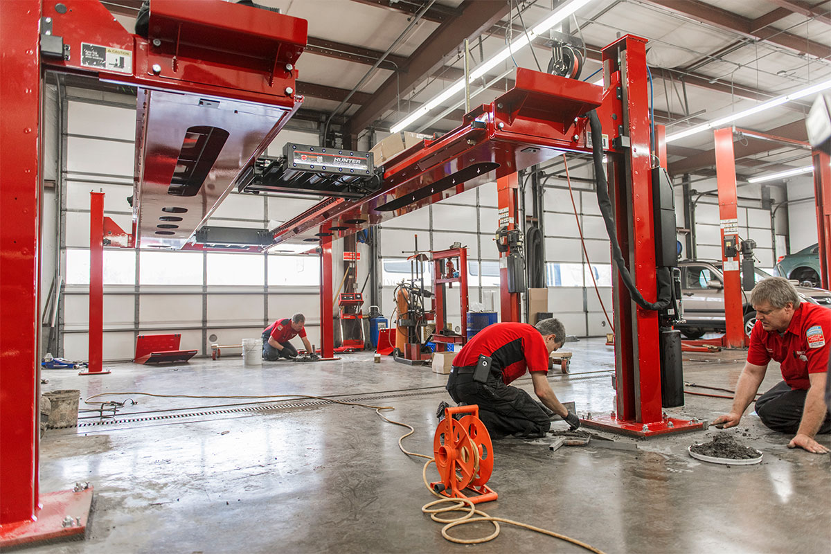 service reps cementing four post lift to floor