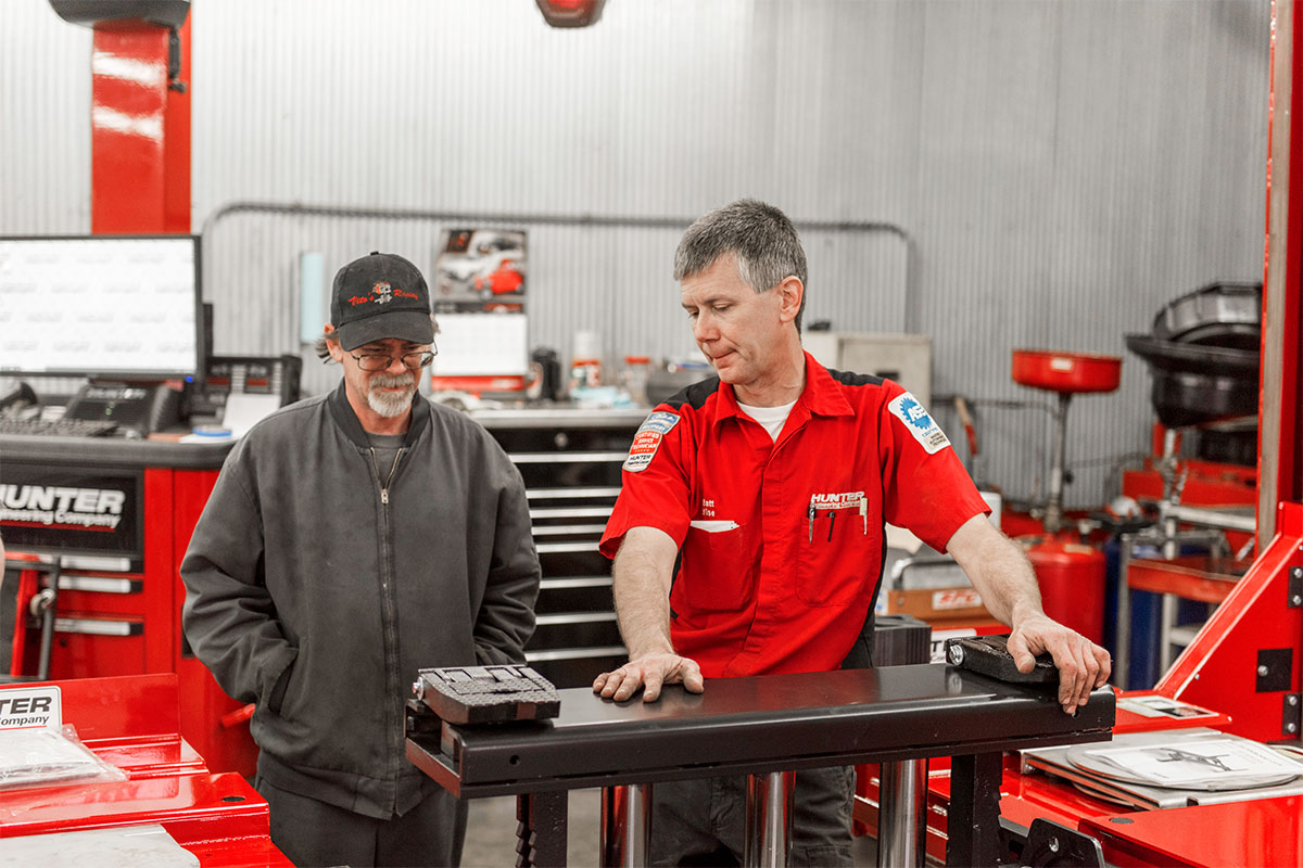 service rep explaining four post lift functions at install