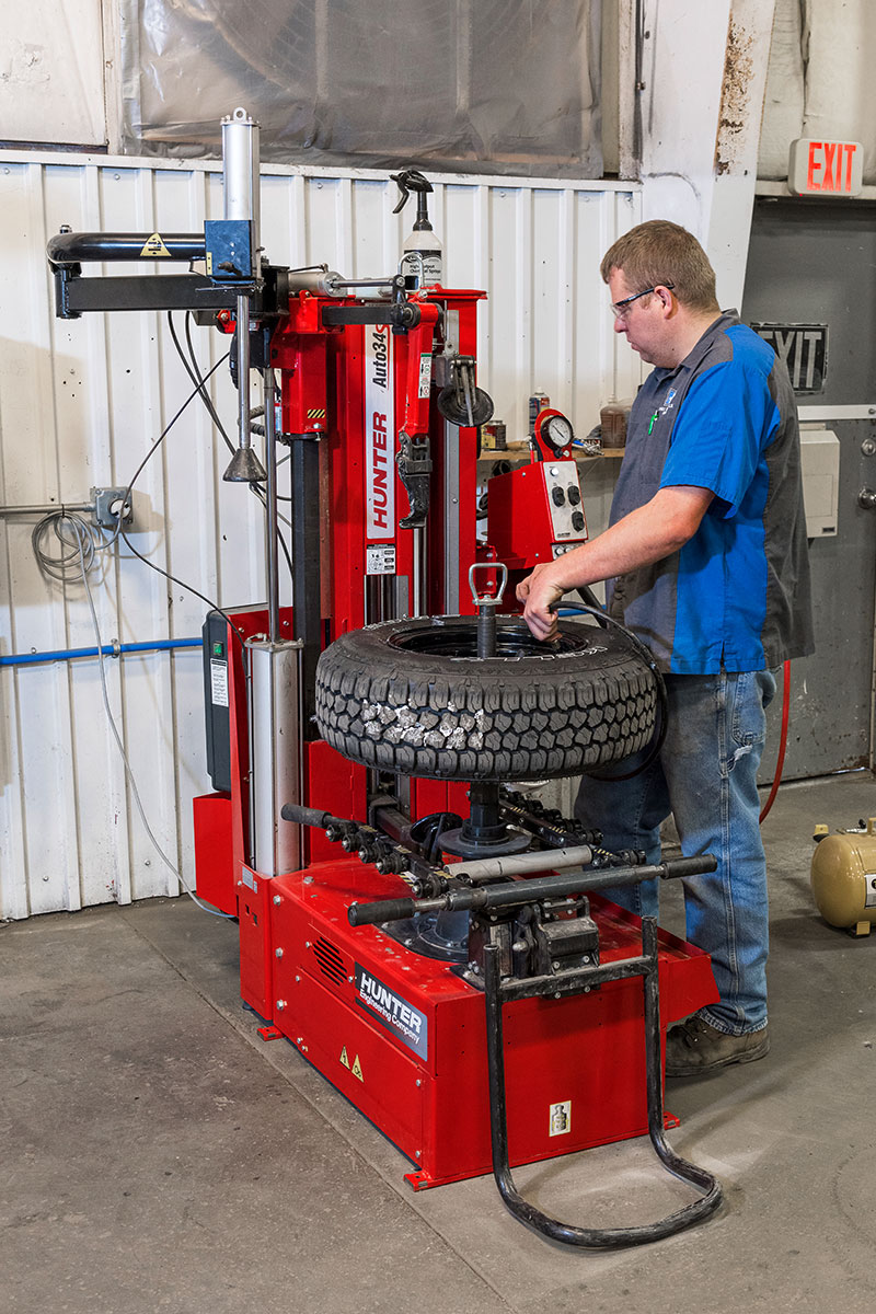 technician using blast inflator on hunter auto34s tire changer