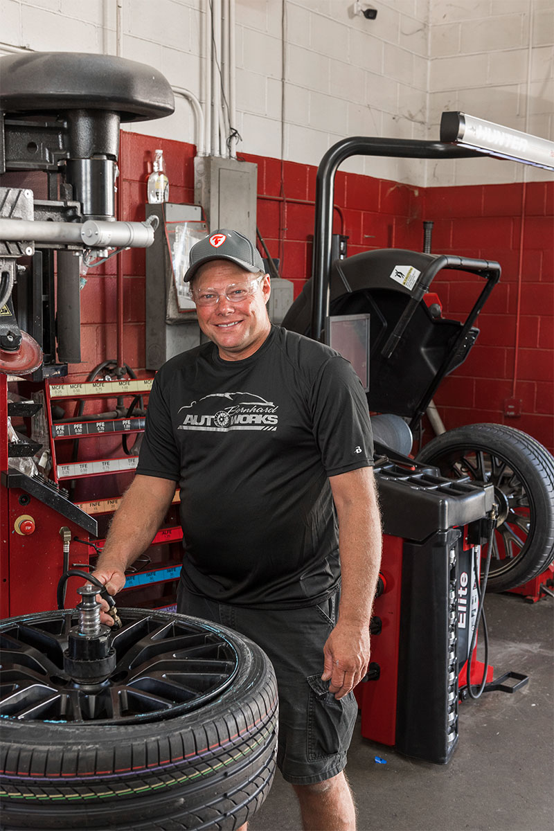 technician smiling while using blast inflation on revolution tire changer